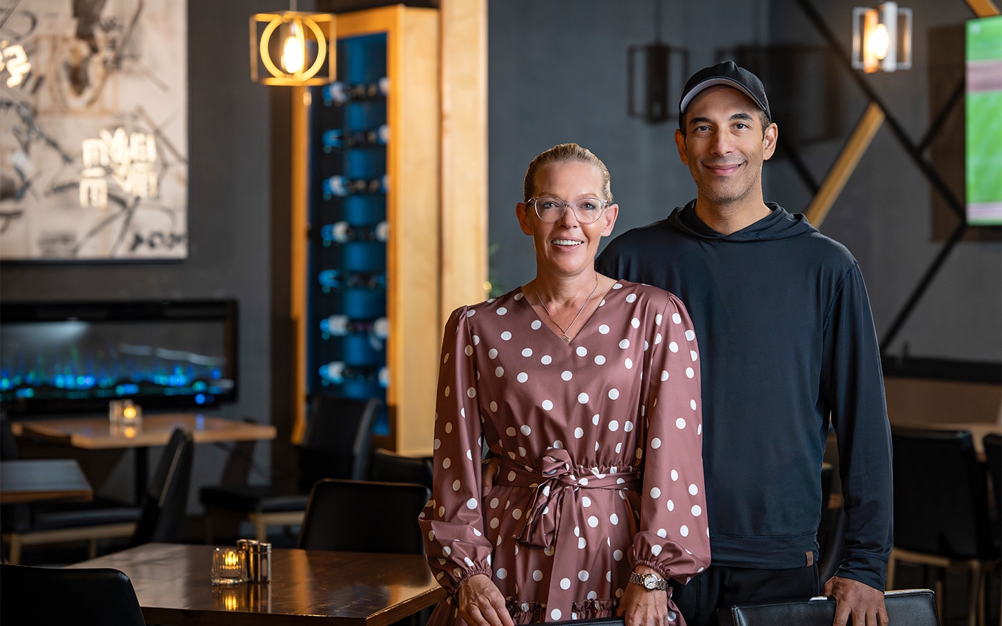 Jess and Nader owners of the Proper in Lloydminster, standing in their restaurant, smiling